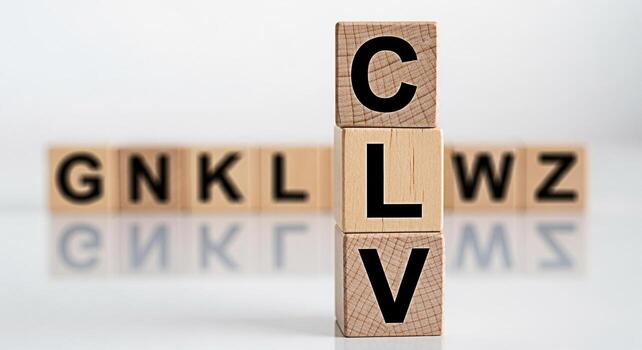 Wooden blocks spelling CLV stacked vertically on a white reflective surface representing Customer Lifetime Value surrounded by blurred blocks with letters conveying a sense of business strategy and fi photo
