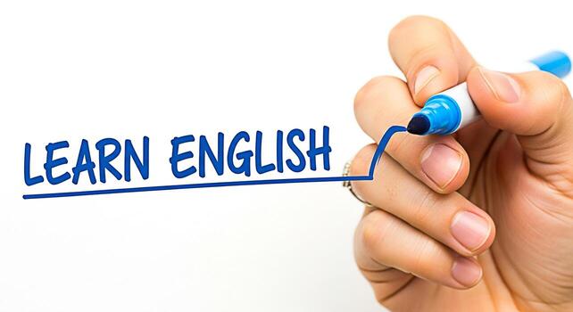 Closeup of a hand writing Learn English on a white surface with a blue marker symbolizing education and language acquisition in a clean bright learning environment conveying a message of knowledge and photo