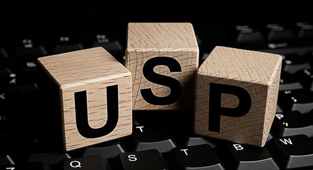 Wooden blocks spelling USP resting on a black computer keyboard symbolizing unique selling proposition in a digital business environment conveying a message of differentiation and competitive advantag photo