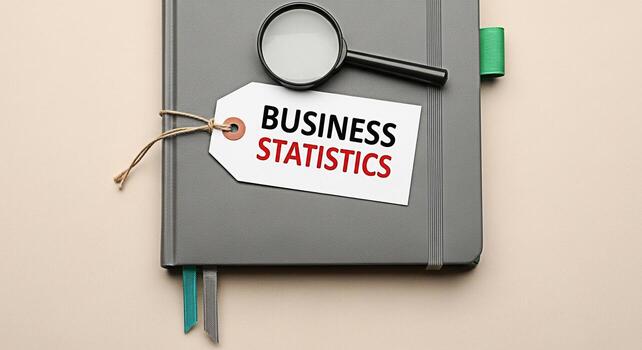 Analyzing business statistics with a magnifying glass on a gray notebook in a bright studio representing data analysis financial review and strategic planning for informed decisionmaking and growth photo