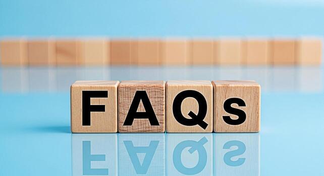 Wooden blocks displaying FAQs on a reflective surface against a blue background representing frequently asked questions and information resources creating a clear and accessible knowledge base for use photo