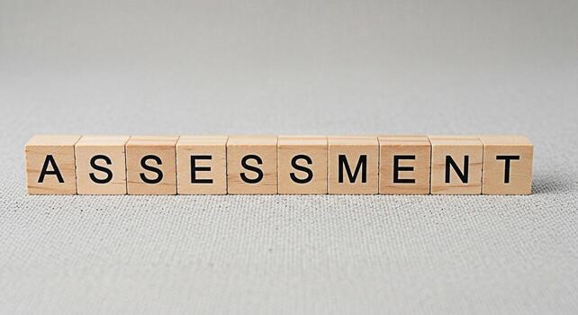 Wooden blocks spelling Assessment on a textured gray surface representing evaluation and analysis in a neutral setting conveying a sense of importance and scrutiny for business education or personal g photo