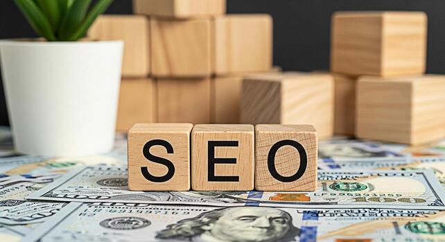 Wooden blocks spelling SEO resting on a bed of hundred dollar bills in a studio setting symbolizing the financial benefits and investment return of search engine optimization strategies for business g photo