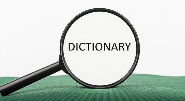 Magnifying glass focusing on the word Dictionary on a green surface symbolizing research learning and the importance of language with a clean and minimalist aesthetic photo