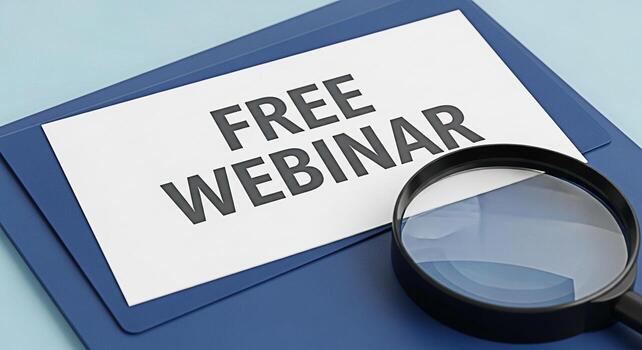 Closeup of a document promoting a free webinar on a blue folder viewed through a magnifying glass highlighting the opportunity for learning and professional development in a convenient online format photo