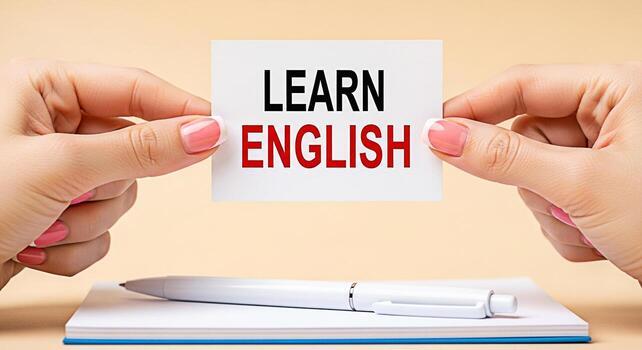 de cerca de cuidado manos participación un tarjeta con el texto aprender Inglés encima un cuaderno y bolígrafo en un beige superficie simbolizando educación idioma adquisición y el importancia de aprendizaje nuevo habilidades F foto