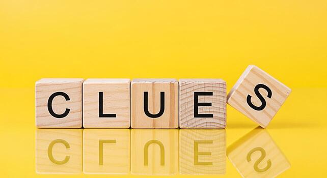 Wooden blocks spelling CLUES on a reflective yellow surface suggesting a mystery or puzzle to be solved creating a sense of intrigue and anticipation for finding answers and uncovering hidden informat photo
