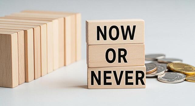 Wooden blocks displaying Now or Never on a white surface surrounded by coins and other blocks conveying a sense of urgency and financial decisionmaking in a minimalist setting ideal for motivational c photo