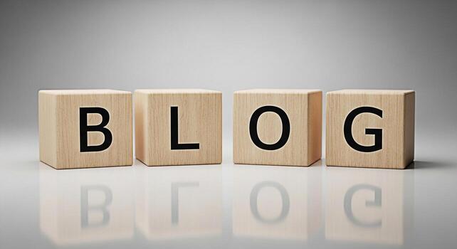 Wooden blocks spelling BLOG sitting on a reflective surface in a brightly lit studio representing online content creation sharing ideas and building an online community with a modern and minimalist ae photo