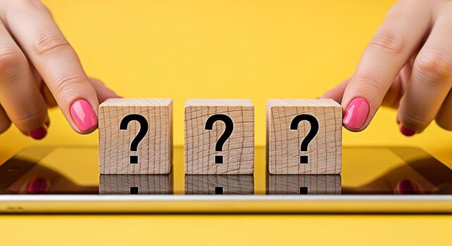 Female hands arranging wooden blocks with question marks on a tablet against a vibrant yellow background symbolizing uncertainty problemsolving and the search for answers in a digital age photo