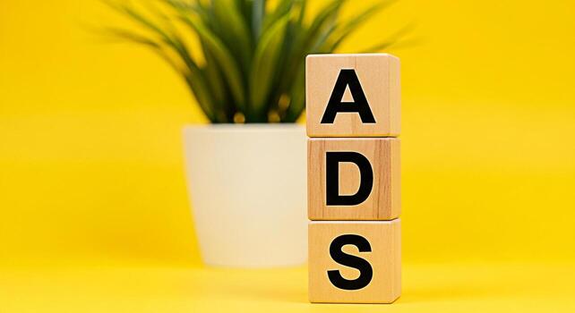 Wooden blocks displaying the word ADS stacked against a vibrant yellow backdrop symbolizing advertising strategies and marketing campaigns creating a bright and optimistic mood for business growth photo