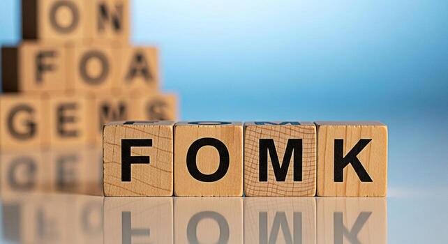 Wooden blocks spelling FOMK in a bright studio setting representing the fear of missing knowledge and the importance of continuous learning and staying informed in todays fastpaced world photo