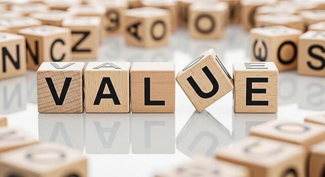 Wooden alphabet blocks spelling out the word VALUE on a reflective surface surrounded by other blocks conveying a sense of importance worth and the fundamental principles of business and personal ethi photo