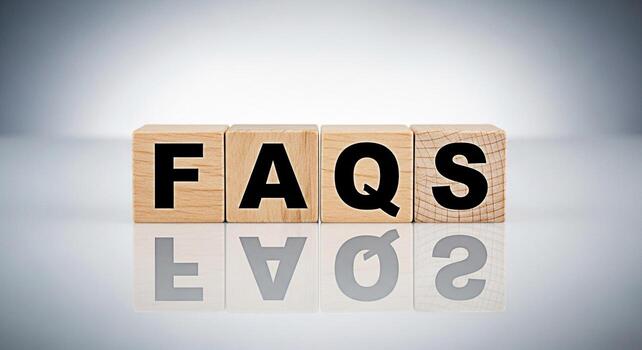 Wooden blocks displaying FAQs on a reflective surface representing frequently asked questions and information accessibility in a clean modern setting emphasizing clarity and helpfulness for users seek photo