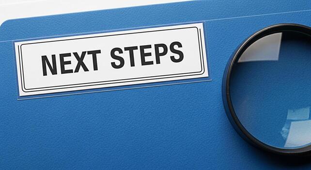 Closeup of a blue file folder with a label reading Next Steps and a magnifying glass symbolizing planning and investigation in a business or educational setting conveying a sense of progress and analy photo