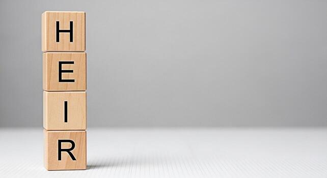 Wooden blocks stacked vertically spelling HEIR on a white surface against a gray background representing legacy inheritance and succession planning for future generations with a sense of responsibilit photo