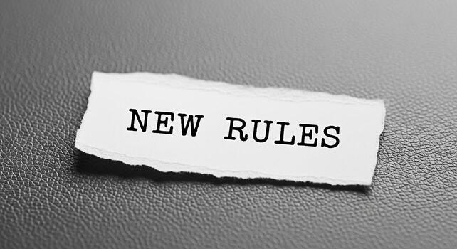 Torn paper scrap displaying New Rules on a textured gray surface symbolizing change adaptation and the need to embrace new guidelines in a dynamic and evolving environment fostering a sense of innovat photo