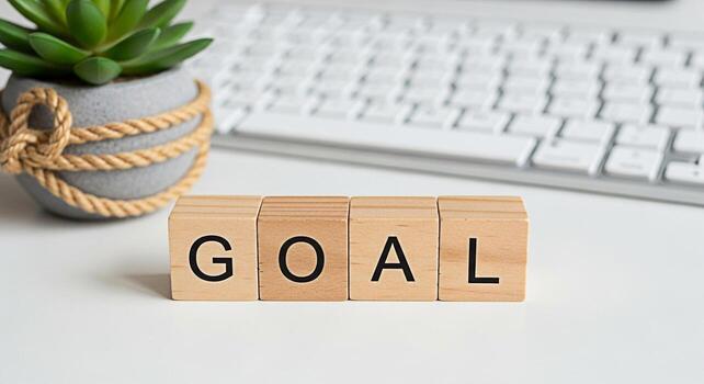 Wooden blocks spelling GOAL on a white desk with a keyboard and succulent symbolizing achievement and determination in a modern workspace fostering a focused and productive environment for success photo