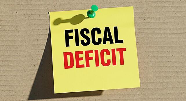Bright yellow sticky note displaying Fiscal Deficit pinned to a textured cardboard surface representing financial challenges and economic concerns in a clear and concise visual message photo