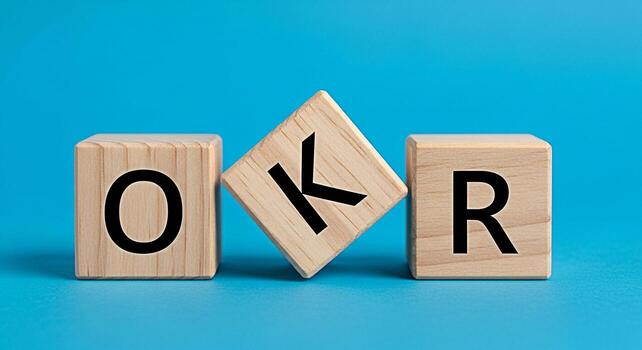 Wooden blocks spelling OKR on a blue surface representing Objectives and Key Results a strategic framework for defining and tracking objectives and outcomes promoting focus and alignment within organi photo
