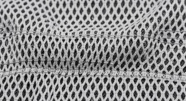 Close-up shot of a gray mesh fabric, highlighting the intricate diamond-shaped patterns and textures, perfect for backgrounds and design elements photo