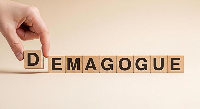 Hand arranging wooden blocks spelling DEMAGOGUE on a neutral background symbolizing manipulation and the dangers of populist rhetoric in political discourse creating a cautionary and thoughtprovoking photo