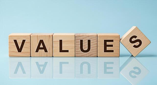 Wooden blocks spelling VALUES on a reflective surface against a light blue background representing core principles and ethical standards conveying a sense of integrity honesty and the importance of mo photo