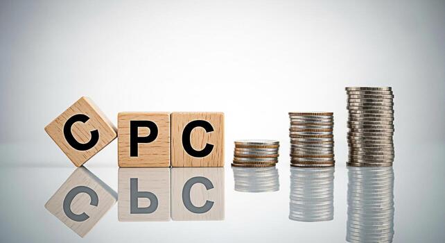 Wooden blocks spelling CPC with stacks of coins on a reflective surface representing cost per click advertising and financial growth in a modern business environment conveying a message of investment photo
