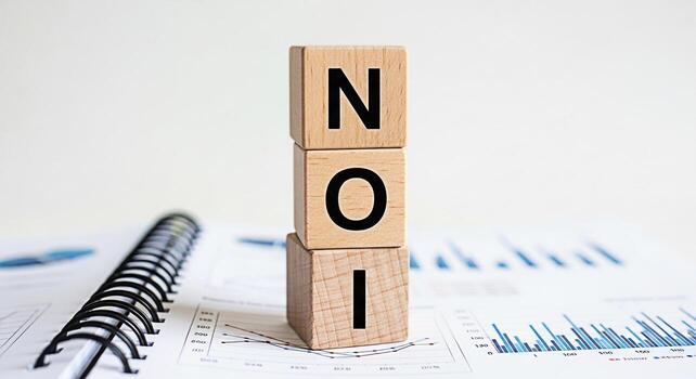 Wooden blocks displaying NOI on top of a financial report in a bright office representing Net Operating Income and financial analysis for business growth and investment strategies conveying a sense of photo