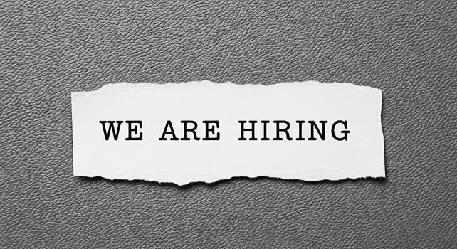 Torn paper message displaying We are hiring on a textured gray background symbolizing opportunity and growth for job seekers in a competitive market creating a sense of urgency and anticipation photo