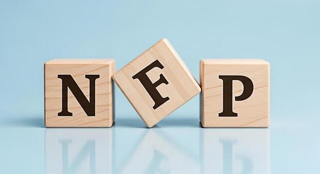 Wooden blocks spelling NFP on a blue reflective surface representing NonFarm Payroll data a key economic indicator conveying a sense of financial analysis and market monitoring in a professional setti photo