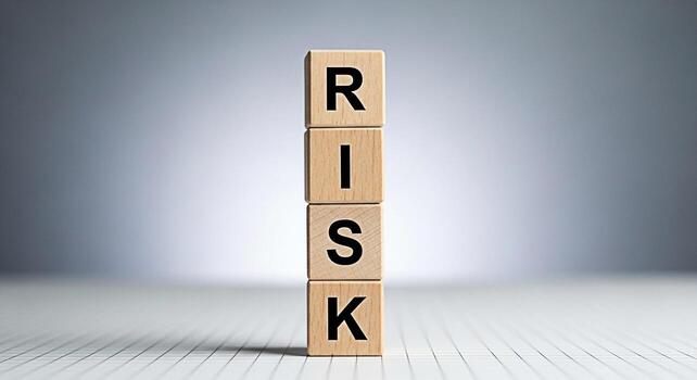 Stacked wooden blocks spelling RISK on a white grid surface representing business challenges and financial uncertainty in a minimalist and conceptual studio setting conveying a sense of calculated dec photo