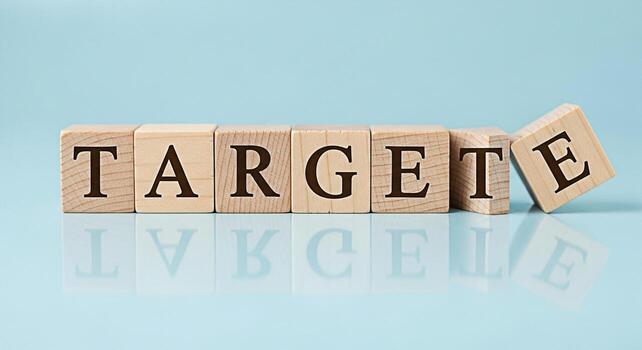 Wooden blocks spelling TARGET on a reflective blue surface representing goal setting and achievement symbolizing focus precision and strategic planning in a business or personal development context photo