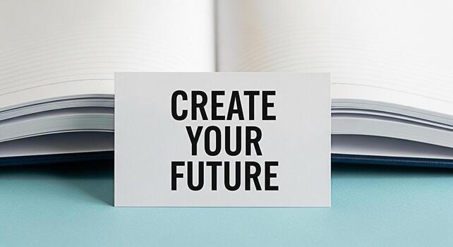 Inspirational message Create Your Future displayed on a business card placed in front of an open notebook on a light blue surface symbolizing planning ambition and the power of positive thinking for s photo