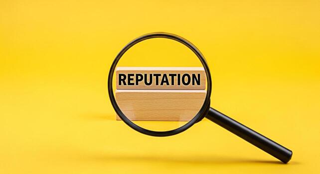 Magnifying glass focusing on the word Reputation displayed on wooden blocks against a vibrant yellow background symbolizing scrutiny importance and the critical nature of maintaining a positive image photo