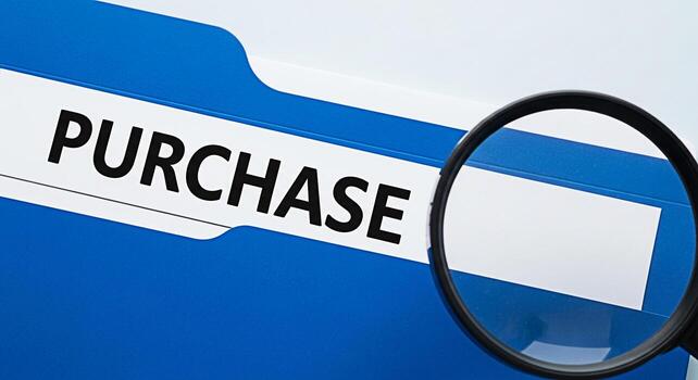 Closeup of a blue file folder labeled Purchase being inspected with a magnifying glass in a bright office setting symbolizing careful review and attention to detail in financial transactions and procu photo