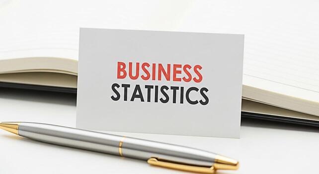 Closeup of a business card displaying Business Statistics next to an open notebook and a pen on a white desk representing data analysis and financial planning in a professional setting photo