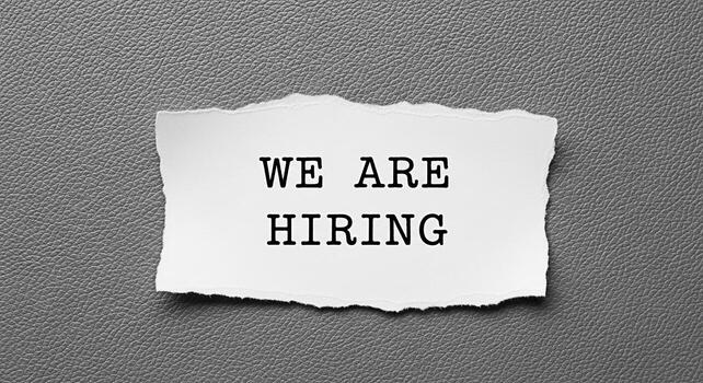 Torn paper displaying We Are Hiring on a textured gray background symbolizing job opportunities and company growth creating a sense of urgency and excitement for potential candidates in a competitive photo