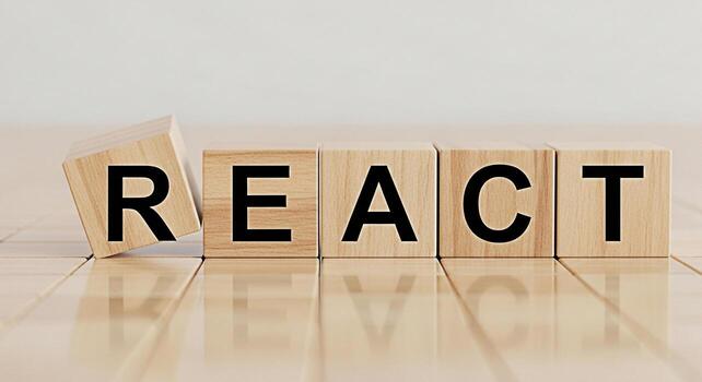 Wooden blocks spelling REACT on a light wooden surface symbolizing a modern JavaScript library for building user interfaces conveying innovation and a focus on frontend development photo