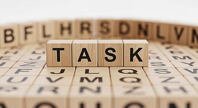 Wooden blocks spelling TASK on a surface covered with lettered blocks symbolizing focus and determination in a bright minimalist setting conveying a sense of organization and achievement perfect for b photo