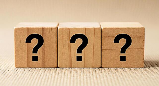 Three wooden blocks displaying question marks on a textured surface representing uncertainty and the need for answers in a conceptual and inquisitive setting evoking curiosity and problemsolving photo