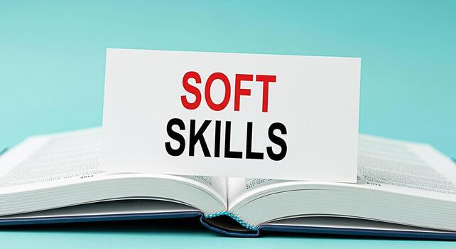 Closeup of a business book displaying a card with the words Soft Skills in red and black set against a clean light blue background symbolizing the importance of interpersonal and emotional intelligenc photo
