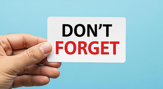 Hand holding a reminder card with the message Dont Forget against a light blue background emphasizing the importance of memory and attention to detail in daily tasks and planning for future events photo