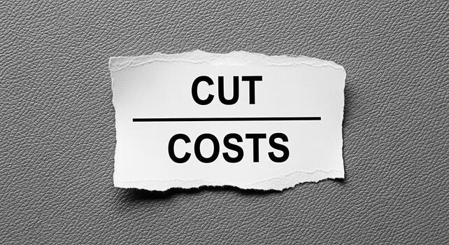 Rasgado papel Nota mostrando cortar costos en un texturizado gris antecedentes simbolizando financiero ahorros y presupuesto reducción en un desafiante económico ambiente enfatizando el necesitar para eficiencia y costo foto