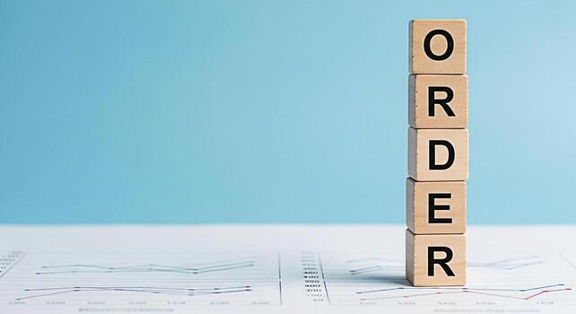 Stacked wooden blocks spelling ORDER on top of financial charts against a light blue background representing business organization systematic planning and a sense of control in a structured environmen photo