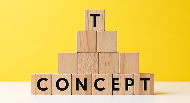 Wooden blocks stacked in a pyramid shape on a white surface against a bright yellow background spelling out the word CONCEPT and topped with a single block with the letter T representing a building bl photo