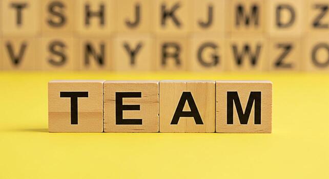 de madera bloques ortografía fuera equipo en un brillante amarillo superficie con borroso alfabeto bloques en el antecedentes simbolizando colaboración unidad y el poder de trabajo en equipo en lograr común metas foto