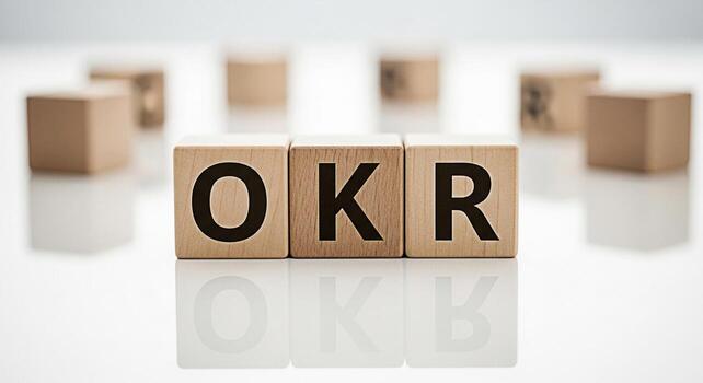 Wooden blocks displaying OKR acronym on a reflective white surface symbolizing Objectives and Key Results in a business setting promoting goalsetting and strategic planning for organizational success photo