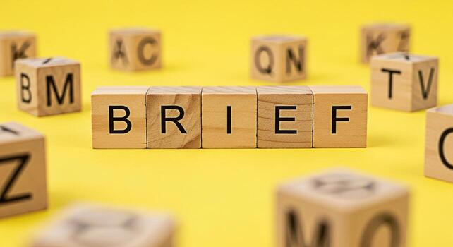 Wooden blocks spelling BRIEF on a bright yellow surface surrounded by other lettered blocks representing a concise and focused message conveying clarity and directness in communication and planning photo