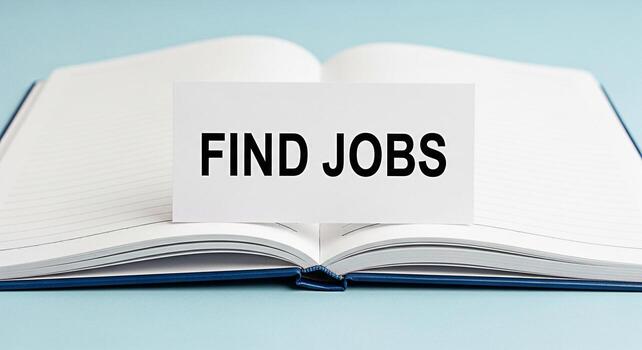 Open notebook displaying a Find Jobs card on a light blue surface symbolizing career opportunities and job searching conveying a message of hope and new beginnings in the professional world photo